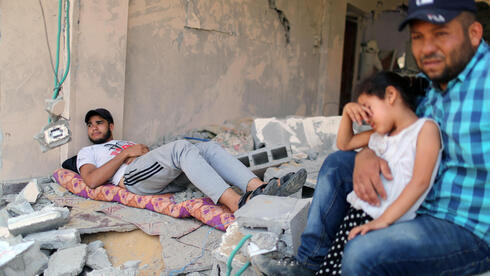  Una familia de Gaza sentada en las ruinas de su casa golpeada por un ataque de las FDI durante el conflicto  de mayo. 