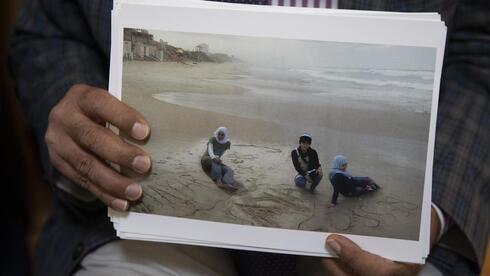  El Dr. Izzeldin Abuelaish sostiene una fotografía de sus hijas y sobrina en la playa de Gaza. 