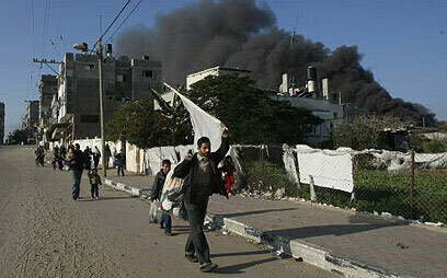 Gazatíes que protestaban, en 2009, contra los ataques de Israel. De fondo, el humo de los bombardeos de las FDI. 