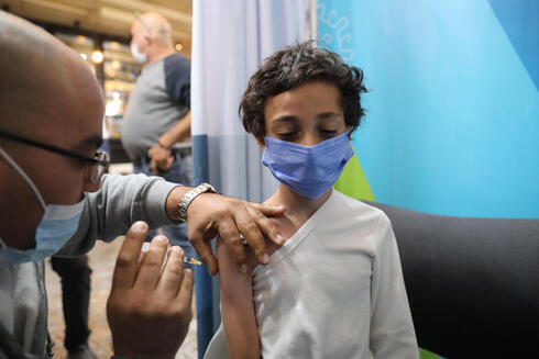 Una niña recibe una dosis de vacuna contra COVID-19 en una clínica de Jerusalem. 