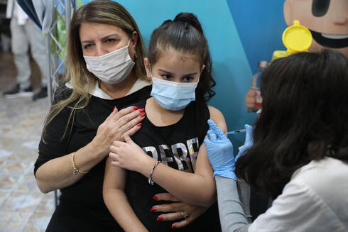 Una niña recibe una dosis de vacuna contra el coronavirus en un centro de Israel. 