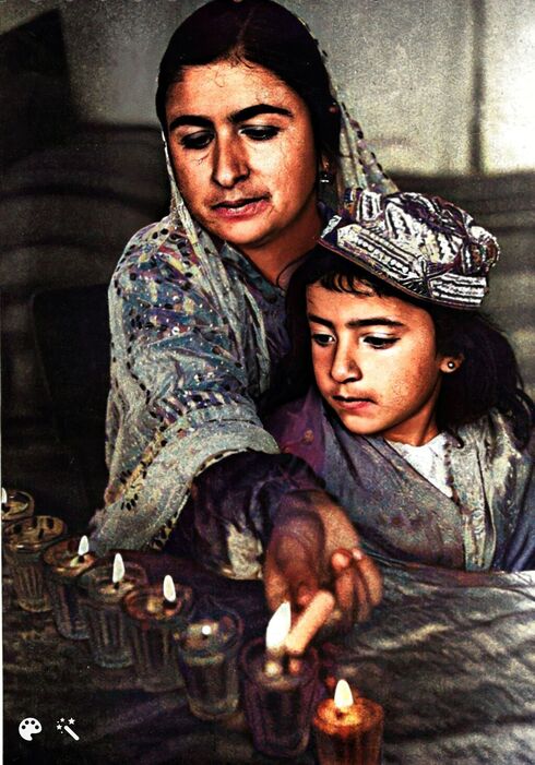 Una madre y su hija inmigrantes de Persia (Irán) encienden una vela de Janucá en 1950.