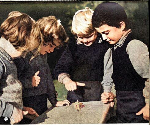 Niños juegan con un rompo girador durante la festividad de Janucá en 1942. (Zultan Kluger/Álbum de Aryeh Ilan/Cortesía del Archivo Yad Ben Zvi y MyHeritage) Niños juegan con un rompo girador durante la festividad de Janucá en 1942.