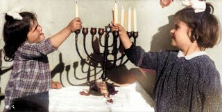 Las hermanas Shlomi y Naomi, hijas de Hugo Herz, encienden una vela de Janucá en Haifa en 1942. 