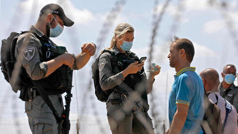 Fuerzas israelíes interrogan a palestinos en un cruce en la frontera con Cisjordania.