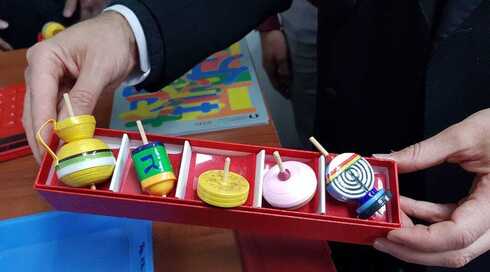 El rabino Moti Grumach con algunos trompos giradores japoneses creados al estilo de los dreidels tradicionales de Janucá. (Cortesía del rabino Grumach/JTA) El rabino Moti Grumach con algunos trompos giradores japoneses creados al estilo de los dreidels tradicionales de Janucá.
