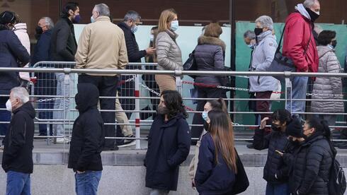  Personas hacen cola para recibir las vacunas de Pfizer contra el COVID-19 en el Centro Wizink en Madrid, España. 