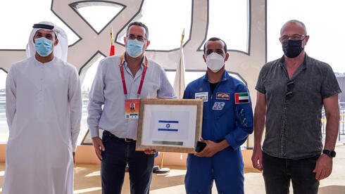 El astronauta de los Emiratos Árabes Unidos entrega la bandera de Israel. 