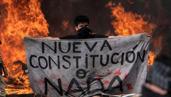 Un manifestante sostiene un trozo de tela que dice "Nueva Constitución o nada" durante una manifestación en Plaza Italia, en Santiago de Chile, el 22 de octubre de 2019. (AFP) Un manifestante sostiene un trozo de tela que dice "Nueva Constitución o nada" durante una manifestación en Plaza Italia, en Santiago de Chile, el 22 de octubre de 2019.
