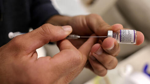 Un médico manipula un vial de la vacuna contra el coronavirus de Pfizer en una clínica de Jerusalem Este.