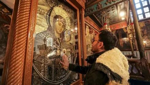  Milad Ayyad ante la imagen de la Virgen en la Iglesia de la Natividad. 