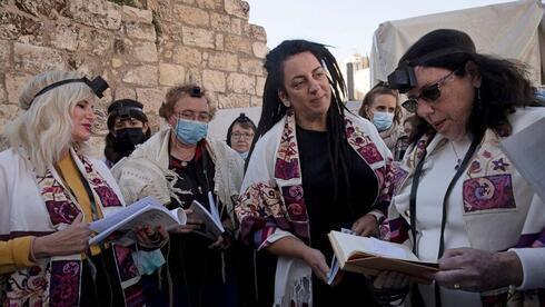 Integrantes de Mujeres del Muro se reúnen alrededor de un rollo de la Torá que el grupo entró oculto para sus oraciones. 