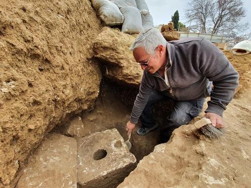 El arqueólogo Ya'akov Billig cerca del antiguo inodoro descubierto en una excavación en Jerusalem. 