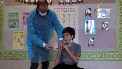 Un niño recibe una vacuna contra el COVID en una escuela. 