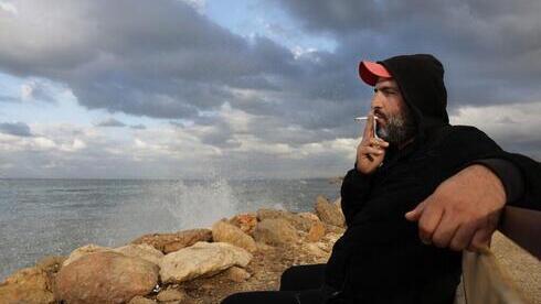 Bilal Moussa, de 34 años, fuma un cigarrillo junto al mar en Trípoli, al norte de Beirut. 