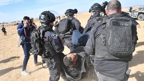 La policía arrastra a un alborotador durante las violentas protestas contra la plantación de árboles en el Negev. 