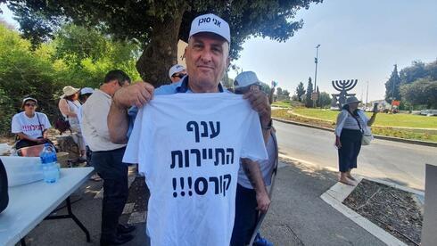  Manifestante de la industria del turismo sosteniendo una camiseta que dice "La industria del turismo está colapsando". 