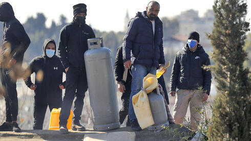 Palestinos con bombonas de gas en un conflictivo barrio de Jerusalem Este. 