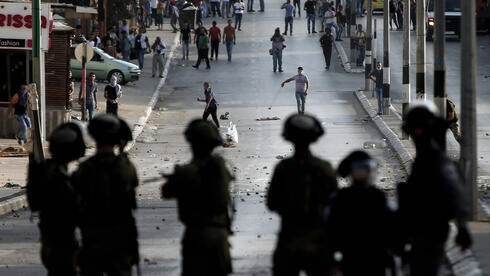 Tropas israelíes se enfrentan con manifestantes palestinos. 