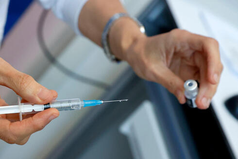 Una enfermera sostiene un vial de la vacuna COVID-19 y una jeringa en una clínica de vacunación en Tel Aviv.