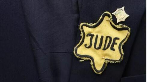 Chaqueta que perteneció al ya fallecido sobreviviente del Holocausto, nacido en Polonia, Mordechai Fuchs, estampada con una insignia de estrella amarilla con la palabra "judío" en alemán inscrita en ella. 