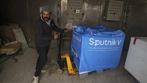 Un trabajador palestino descarga las vacunas Sputnik enviadas a Gaza desde Emiratos Arabes Unidos. 