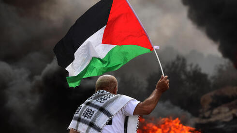 Un manifestante palestino sostiene una bandera durante los enfrentamientos en Cisjordania en septiembre pasado. . 