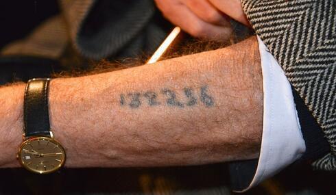 Un sobreviviente muestra su tatuaje del campo de concentración de Auschwitz. 