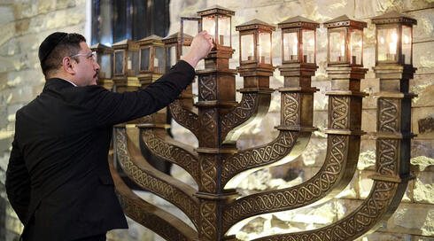 El rabino Yaakov Baruch enciende una menorá en la sinagoga Shaar HaShamayim de Indonesia. 