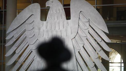 Rabino sentado frenta al águila heráldica de Alemania durante una conmemoración del Holocausto en el Bundestag. 
