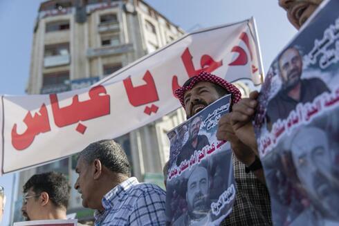 Manifestantes palestinos llevan carteles que dicen "Vete Abbas". 