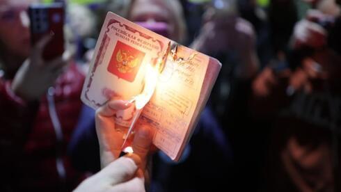 Un manifestante procede a la quema de un pasaporte ruso. 
