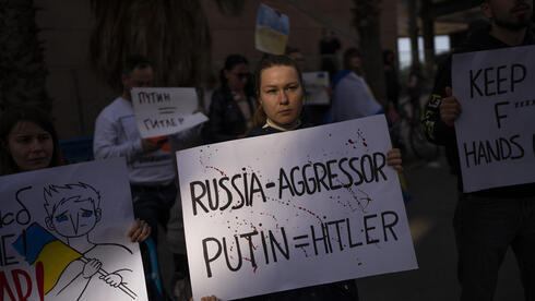 Una manifestante con un cartel que compara a Putin con Hitler, en la protesta de Tel Aviv