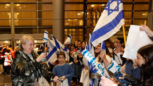 Una inmigrante ucraniana es recibida con banderas de Israel en el aeropuerto Ben Gurion. 