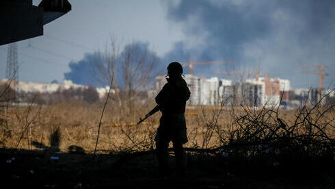 Un soldado ucraniano observa el humo de los bombardeos sobre Irpin, Ucrania, 