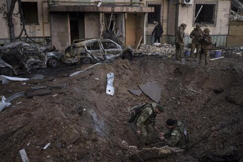 Un escuadrón antibombas ucraniano inspecciona el lugar de una explosión después de un bombardeo en Kiev. 