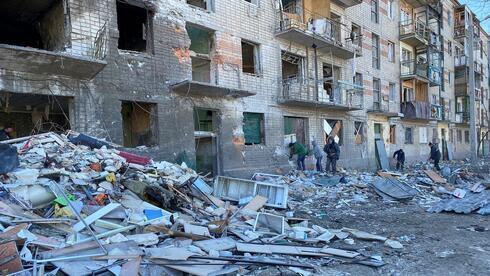 Trabajadores municipales y voluntarios retiran los escombros de un edificio residencial dañado, mientras continúa el ataque de Rusia a Ucrania, en Kharkiv.