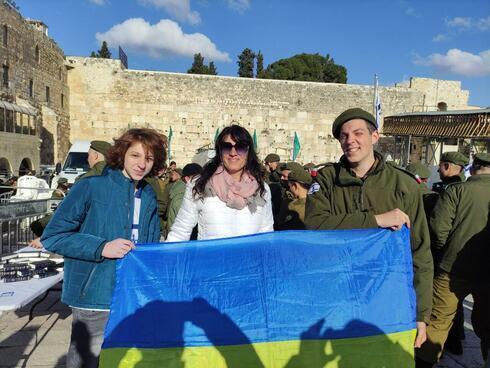 Albert, Tatiana y Arkady Kesselman sostienen la bandera ucraniana en el Muro Occidental de Jerusalem. 