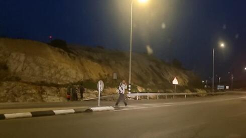 Palestinos llegan a la carretera cerca de la valla divisoria. 