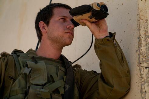 Un soldado de las FDI sostiene unos prismáticos.