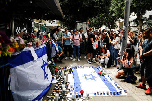Civiles celebran una vigilia y encienden velas en memoria de las víctimas en el pub de Tel Aviv donde se produjo el tiroteo.