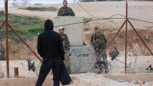 Un militante palestino, frente a tropas de las FDI en la valla perimetral de Cisjordania. 