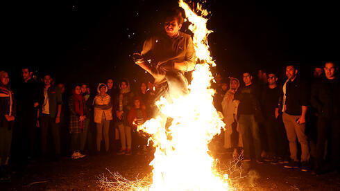La tradicional ceremonia de salto de fuego durante la celebración del Nowruz, cerca de Teherán, 2019.
