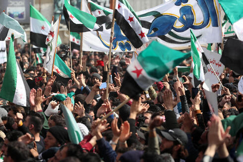 Manifestantes ondean banderas de la oposición siria durante una manifestación en la ciudad siria de Idlib, controlada por los rebeldes. 