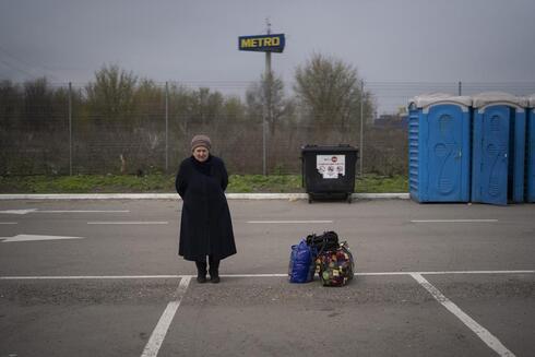 Una mujer de nombre Helena permanece de pie junto a sus pertenencias luego de llegar desde la ciudad de Mariúpol a un centro de refugiados, el jueves 21 de abril de 2022, en Zaporiyia, Ucrania.