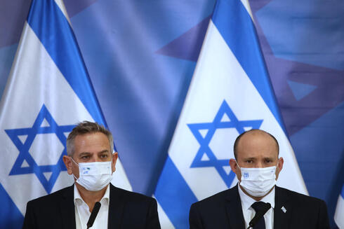 El ministro de Salud, Nitzan Horowitz, y el primer ministro Naftalí Bennett, con barbijos, durante una conferencia de prensa el año pasado. (Moti Milrod) El ministro de Salud, Nitzan Horowitz, y el primer ministro Naftalí Bennett, con barbijos, durante una conferencia de prensa el año pasado.
