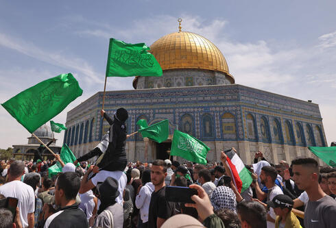 Palestinos ondeando banderas de Hamas en el complejo de la mezquita de al-Aqsa en Jerusalem.  