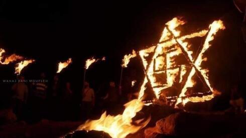 Palestinos incendian una estrella de David con una esvástica.