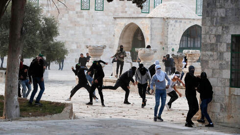 Palestinos arrojan piedras a la policía en el complejo de la mezquita de Al Aqsa a principios de este mes. 