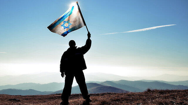 Un hombre flamea una bandera israelí. 